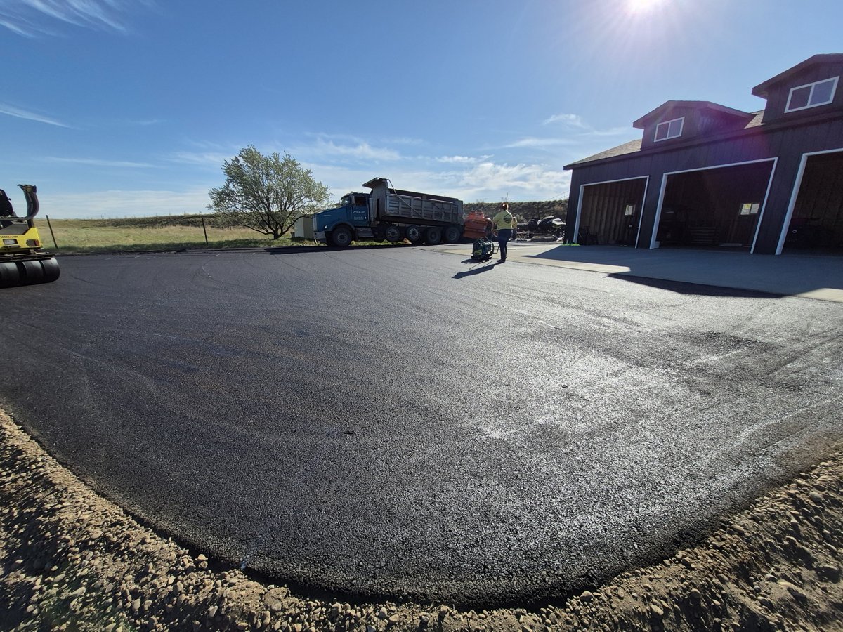 Williston Paving crew laying fresh asphalt with a PavMaster paver